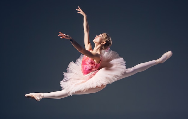 Beautiful female ballet dancer on a grey background