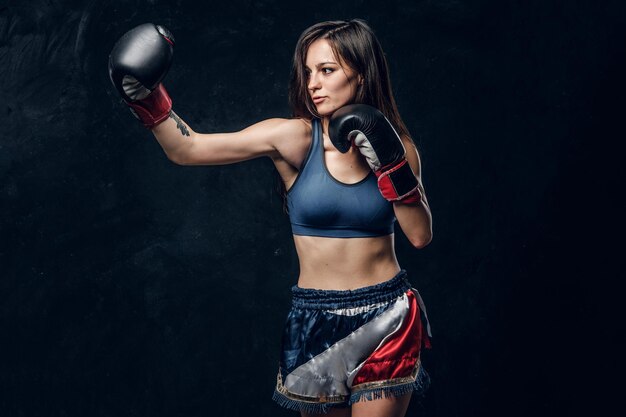 Beautiful female boxer is demonstrating her tactic attack while posing for photographer.