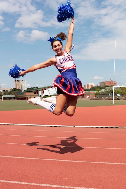 Beautiful female cheerleader in cute uniform