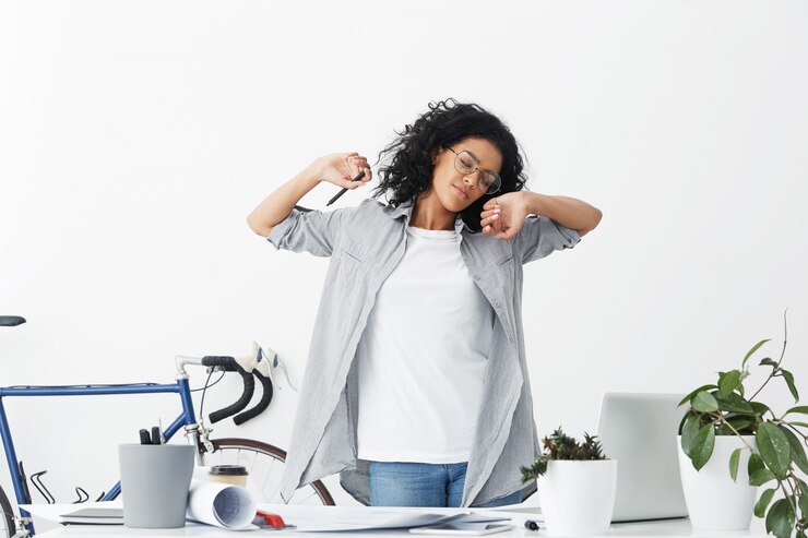Free Photo beautiful female design worker having voluminous dark hair wearing casual shirt being tired