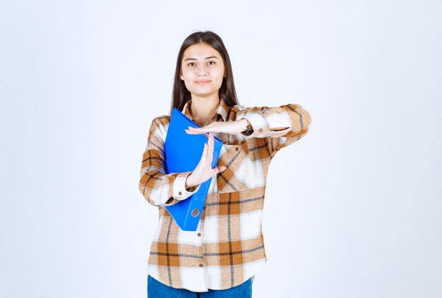 Beautiful female employee with blue folder smiling .