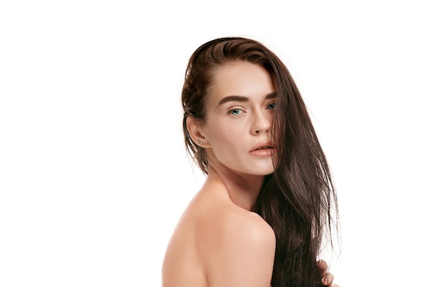 美しい女性の顔。白いスタジオの背景に若い白人女性の完璧できれいな肌。