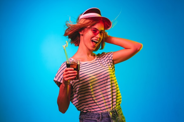 Beautiful female half-length portrait isolated on blue neon lights studio