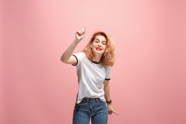 Beautiful female half-length portrait isolated on pink wall. The young emotional surprised woman