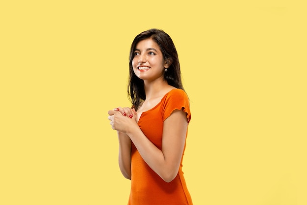 Foto gratuita bellissimo ritratto femminile a mezzo busto isolato su sfondo giallo studio. giovane donna indiana emotiva in abito stupito e felice. spazio negativo. espressione facciale, concetto di emozioni umane.