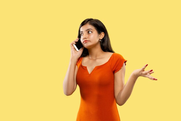 Beautiful female half-length portrait isolated on yellow