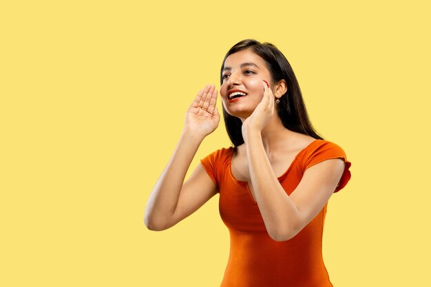 Beautiful female half-length portrait isolated on yellow