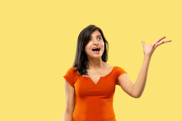 Beautiful female half-length portrait isolated. Young emotional indian woman in dress astonished and happy. Negative space. Facial expression, human emotions concept.