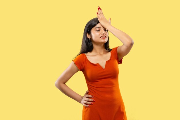 Beautiful female half-length portrait isolated. Young emotional indian woman in dress remembering something. Negative space. Facial expression, human emotions concept.