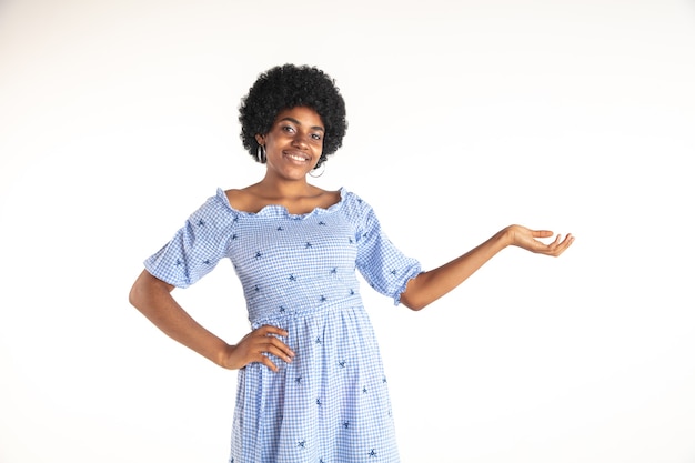 Free photo beautiful female half-length portrait on white  wall. young emotional african-american woman in blue dress. facial expression, human emotions concept. gesturing, inviting, showing.