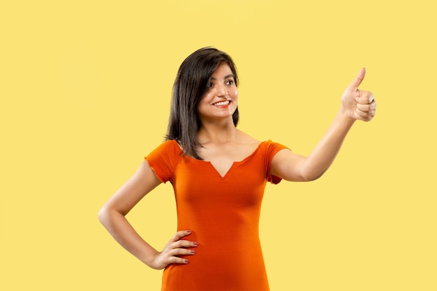 Beautiful female half-length portrait on yellow studio