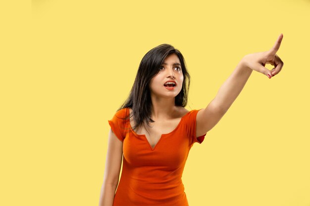 Beautiful female half-length portrait on yellow studio