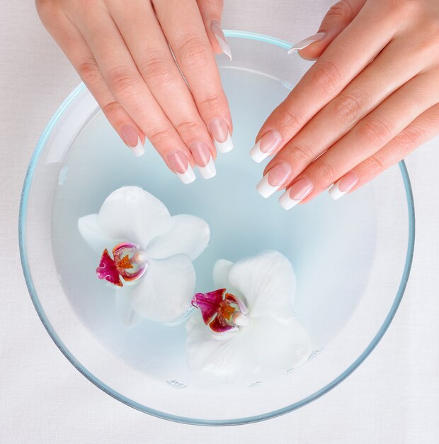 Beautiful female hands with french manicure preparing for getting spa procedure