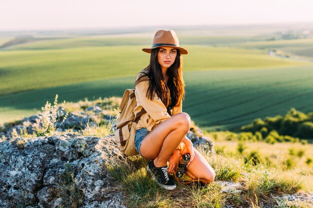 Beautiful female hiker posing on rock