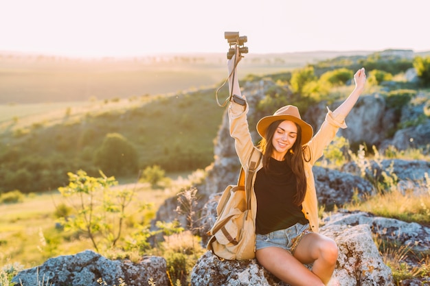 Beautiful female hiker relaxing on rock