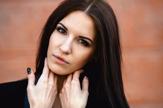 Beautiful female in a jacket by the wall