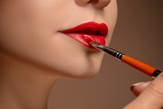 Beautiful female lips with make-up and brush