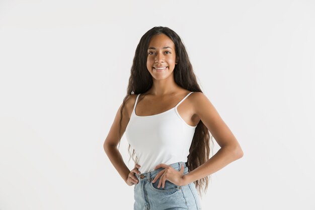 Beautiful female portrait isolated. Young emotional african-american woman with long hair. Facial expression, human emotions concept. Standing and smiling.