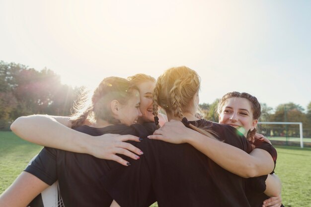 Beautiful female sport team embracing