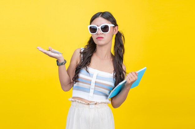 Beautiful female students hold notebooks and pens