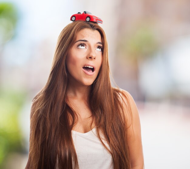 彼女の頭の上の車のモデルと美しい女性