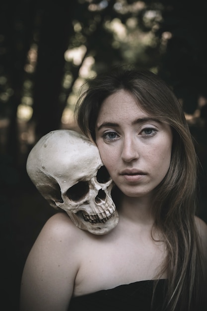 Free photo beautiful female with skull in woods