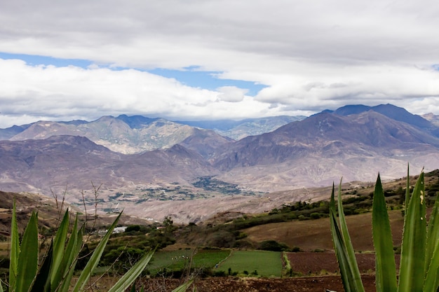 Free photo beautiful field with amazing rocky mountains and hills and amazing cloudy sky