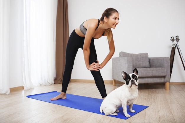 Beautiful fitness girl  make sport exercises with dog