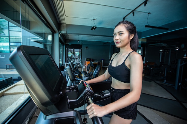 Beautiful fitness women prepare for running at the treadmill in the gym.