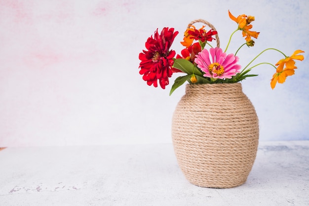 Beautiful flowers in the vase on grunge backdrop