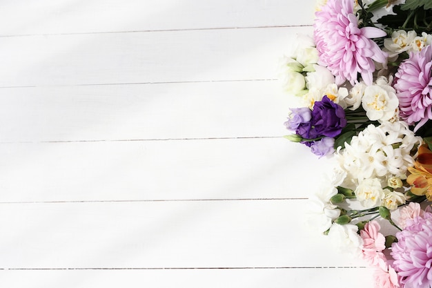 Beautiful flowers on wooden background