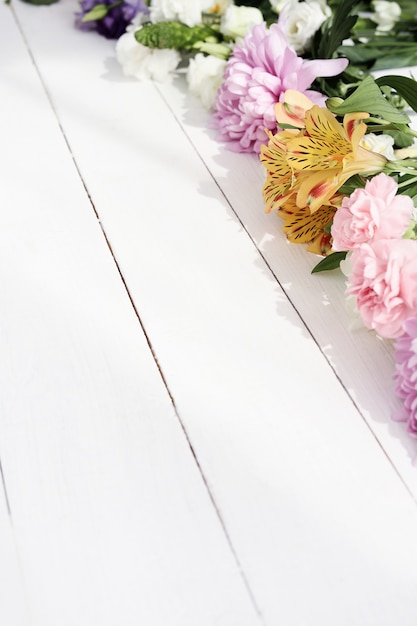 Beautiful flowers on wooden background