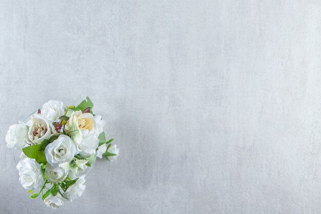 白いテーブルの上に、美しい香りの花とガラス。