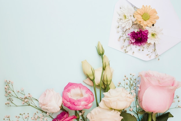 色とりどりの背景に封筒と美しい新鮮な花の装飾