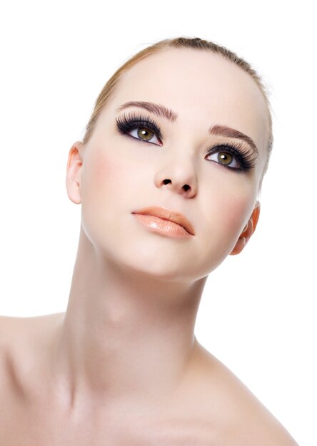 Beautiful fresh woman's face with black eye makeup  isolated on white