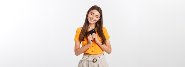 Beautiful friendly smiling confident girl showing black card in hand isolated over white background