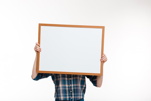 beautiful ginger girl with whiteboard over white wall.