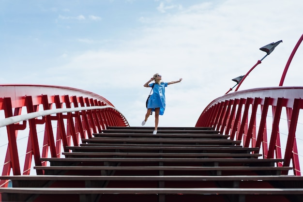 beautiful girl in a blue dress posing on the bridge