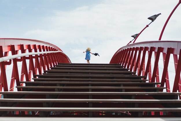 красивая девушка в голубом платье позирует на мосту
