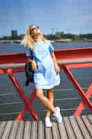 Free photo beautiful girl in a blue dress posing on the bridge