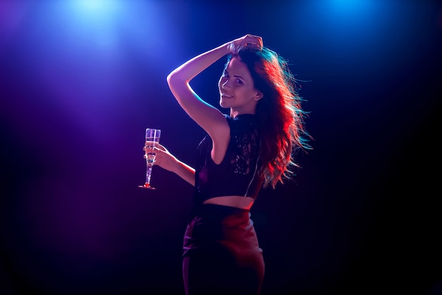 Красивая девушка танцует на вечеринке пьет шампанское