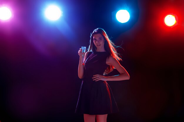 The beautiful girl dancing at the party drinking champagne