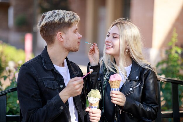 Красивая девушка дарит мороженое своему парню