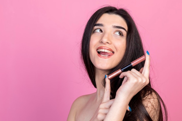 Beautiful girl holding her lipstick and taking out her tongue High quality photo