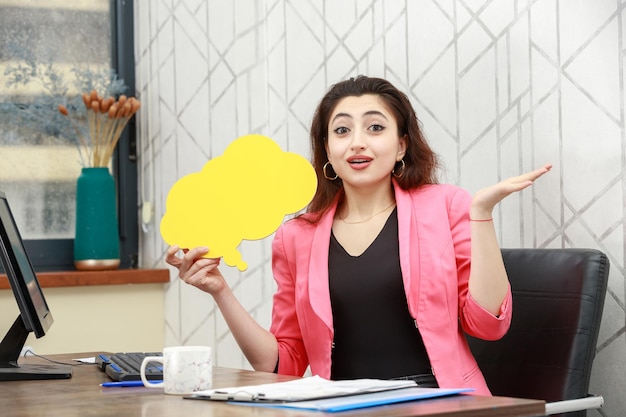 Beautiful girl holding yellow idea bubble in a cloud shape and seems excited High quality photo