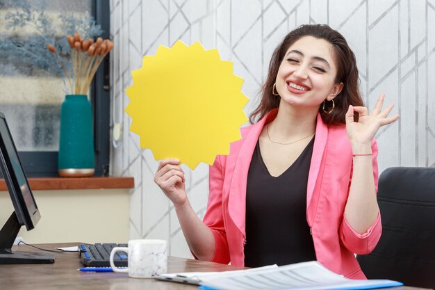 Beautiful girl holding yellow idea bubble and gestures ok High quality photo