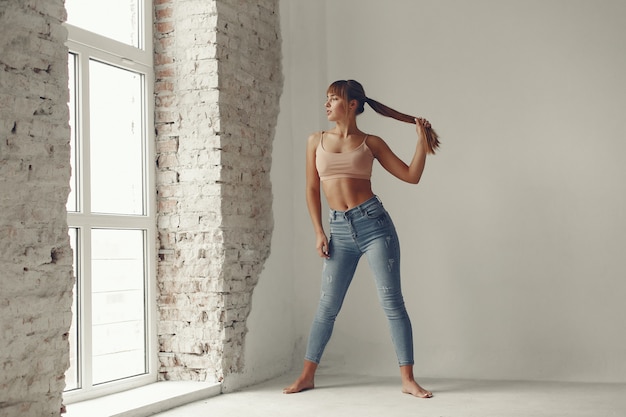 Free photo a beautiful girl is engaged in a yoga studio