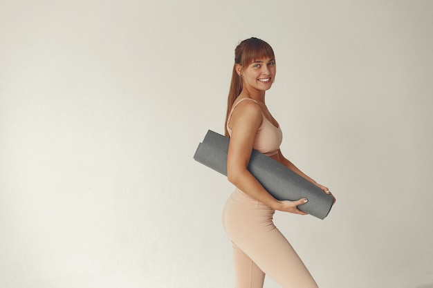 A beautiful girl is engaged in a yoga studio