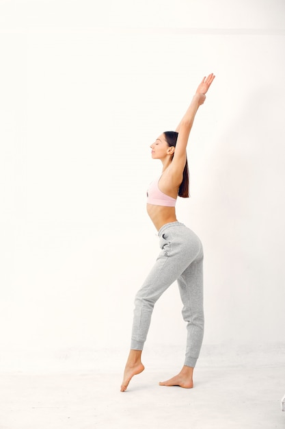 Una bella ragazza è impegnata in uno studio di yoga