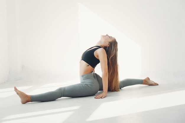 Una bella ragazza è impegnata in uno studio di yoga